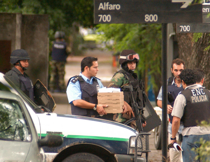 Pizzákat visz be egy rendőr a 2006. január 13-án megtámadott bankba a túszoknak Argentínában – Fotó: Laura Tenenbaum / NA /AFP
