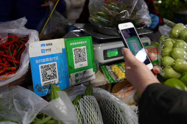 Egy vásárló az Alipay megoldásával fizet egy pekingi piacon 2020 novemberében – Fotó: Greg Baker / AFP