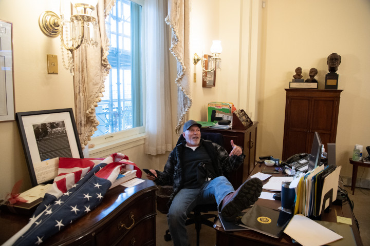 Tüntető Pelosi asztalánál az ostrom idején – Fotó: Saul Loeb / AFP
