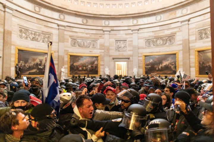 Tüntetőkkel dulakodó rendőrök a Capitolium kupolatermében, és az elhíresült fotó a képviselőházi ülésterem bejáratát fegyverrel védő őrökről – Fotó: Mostafa Bassim / Anadolu Agency / AFP – Drew Anger / Getty Images / AFP