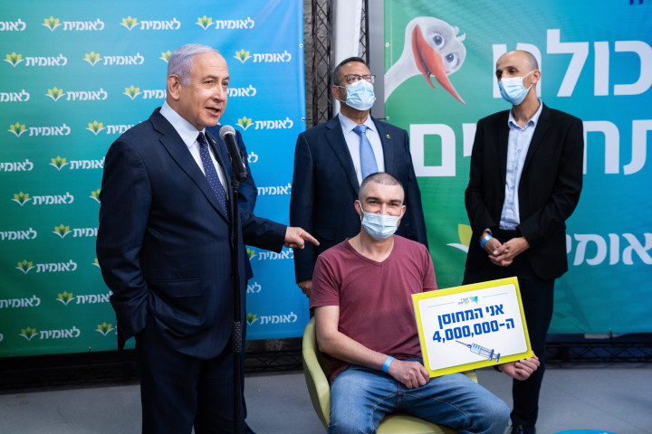 Benjámin Netanjahu izraeli miniszterelnök a négymilliomodik koronavírus elleni oltásban részesült személy mellett áll egy jeruzsálemi oltóközpontban február 16-án.Fotó: Alex Kolomoiszki / MTI/EPA/Jediót Ahronót