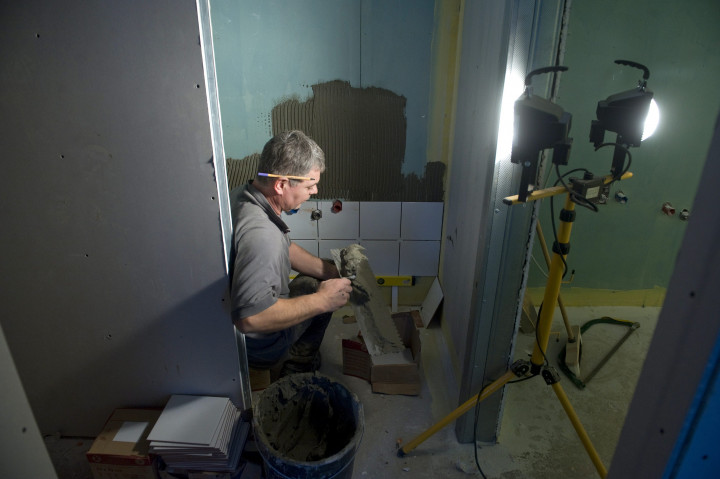 Szakember dolgozik egy családi házban – Fotó: Koszticsák Szilárd / MTI