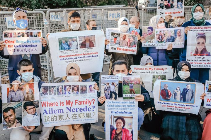 Ujgur menekültek tüntetnek kezükben eltűnt hozzátartozóik képével Isztambulban, a kínai nagykövetség épülete előtt 2020 decemberében – Fotó: Bulent Kilic / AFP