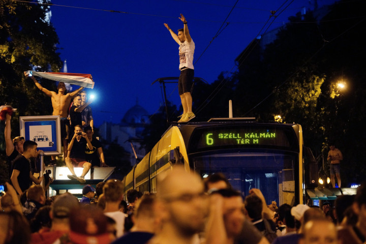 Villamos tetején áll egy szurkoló az ünneplő tömeg között a fővárosi Erzsébet körúton a Wesselényi utca közelében a franciaországi labdarúgó Európa-bajnokság F csoportja második fordulójában játszott Izland–Magyarország mérkőzés végén,+ 2016. június 18-án – Fotó: Balogh Zoltán / MTI