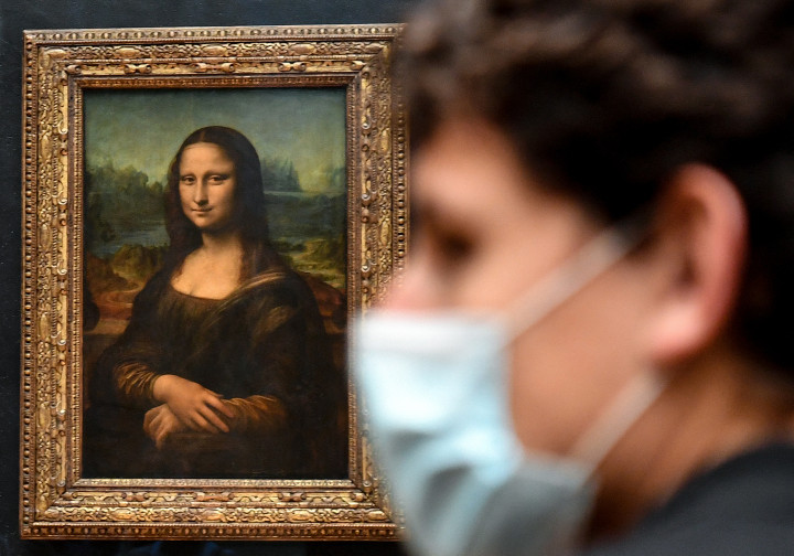 Egy látogató sétál el az eredeti Mona Lisa mellett a párizsi Louvre-ban. Forrás: Alain Jocard / AFP