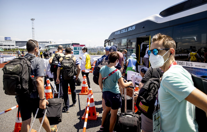Médiamunkások szállnak fel az olimpia sajtóközpontjába tartó buszra 2021. július 22-én – Fotó: Koen van Weel / ANP MAG / ANP / AFP