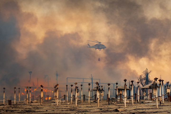 Helikopter vesz részt a tűzoltásban a Le Capannine strand felett Catanában, Szicíliában 2021. július 30-án – Fotó: Roberto Viglianisi / Reuters