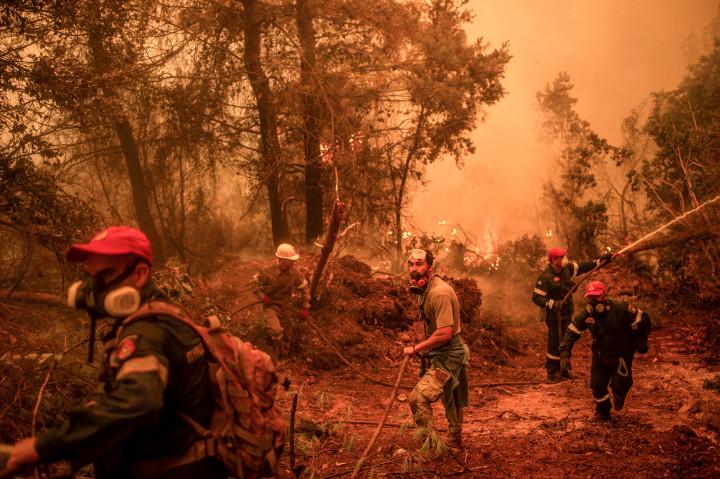 Tűzoltók és önkéntesek vesznek részt az oltásban Evia Glastona településén 2021. augusztus 9-én – Fotó: ANGELOS TZORTZINIS / AFP