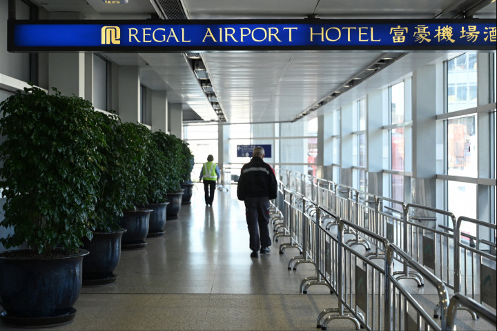 Hong Kong Chek Lap Kok repülőterén lévő Regal Airport Hotelbe tartó emberek 2021. november 26-án, ahol korábban egy dél-afrikai utazónál azonosították a koronavírus új variánsát – Fotó: Peter Parks / AFP